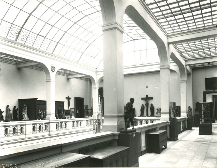 Historische Aufnahme der Oberlichthalle um 1909. Entlang des Geländers stehen Skulpturen, von oben fällt Licht durch die Glasdecke. Foto: LVR-LandesMuseum Bonn.