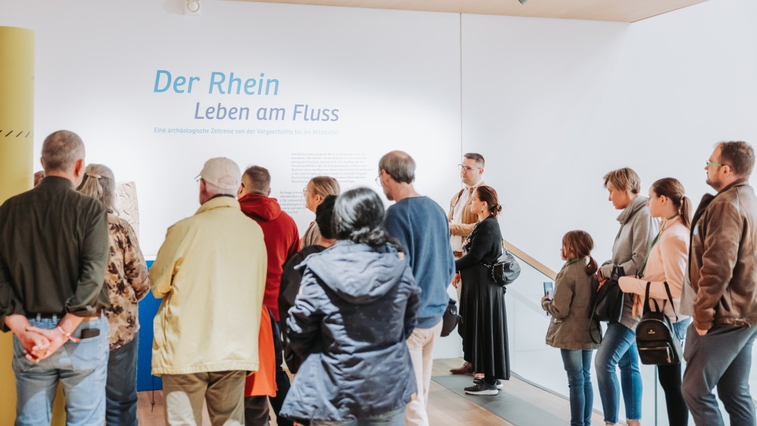 Besuchende lassen sich durch die Ausstellung "Der Rhein. Leben am Fluss" führen