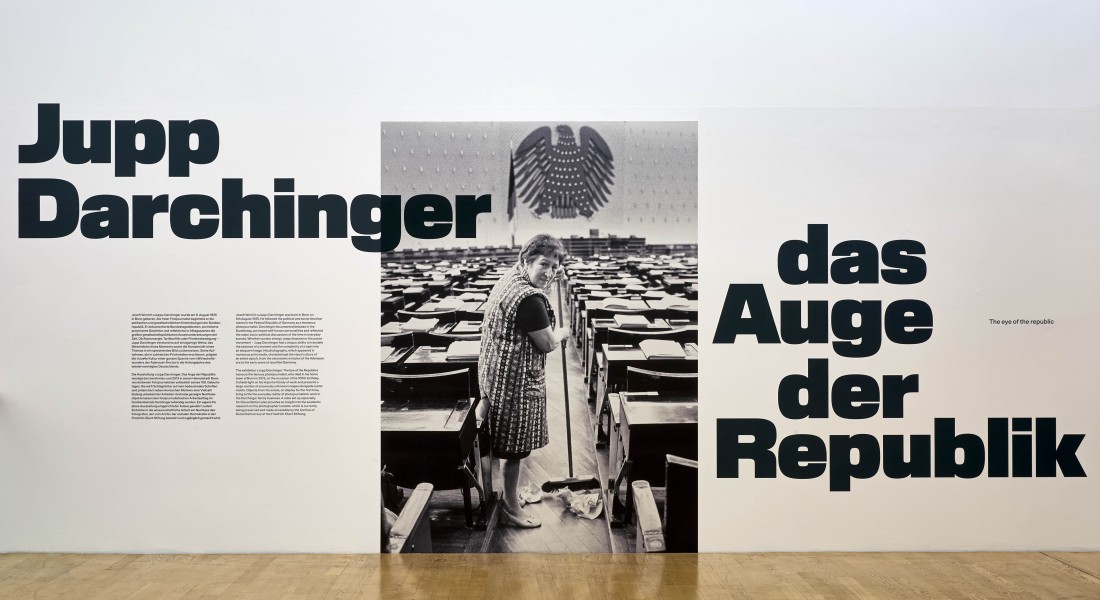Das Keyvisual zu Jupp Darchinger zeigt eine Raumpflegerin im alten Bundestag.