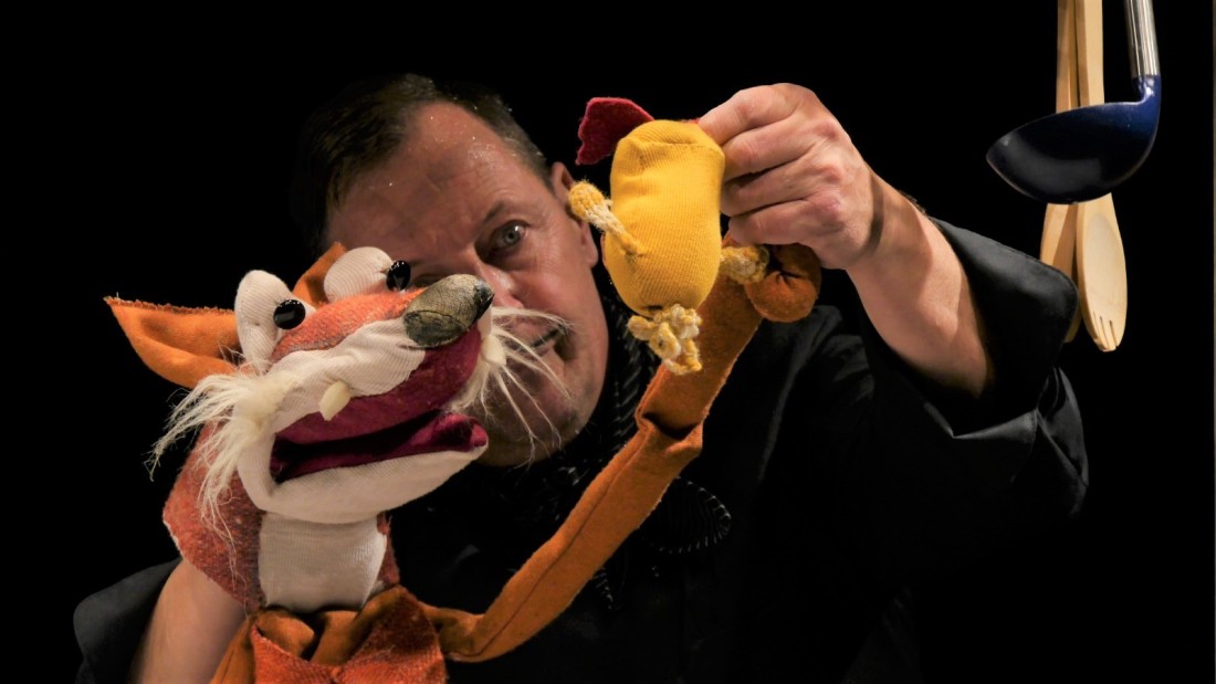 Ein Puppenspieler hält eine Fuchs-Handpuppe.
