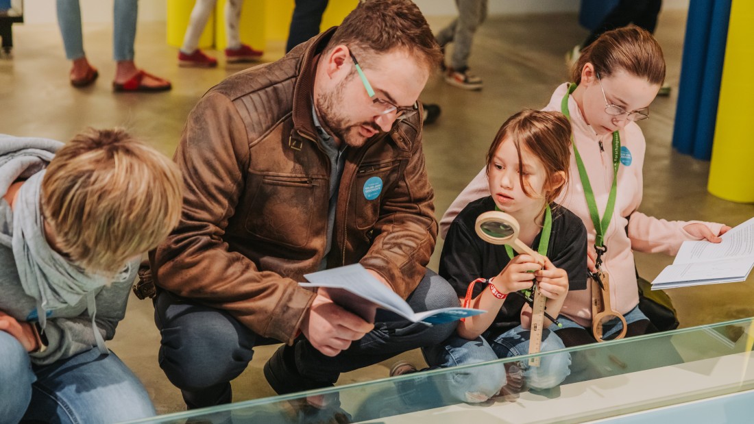 Eine Familie entdeckt die Präsentation "Der Rhein. Leben am Fluss" mit dem Mitmachset.