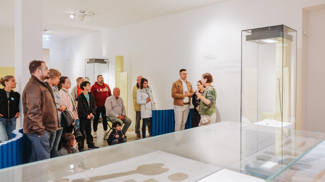 Besuchende entdecken die Präsentation "Der Rhein. Leben am Fluss" mit einem Museumsguide. 