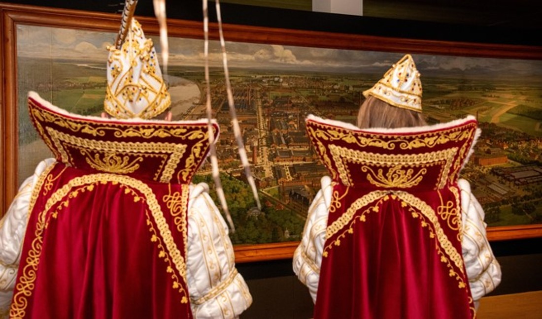 Zwei Karnevalisten betrachten ein Gem&auml;lde in der Ausstellung "Sch&ouml;ne neue Arbeitswelt".