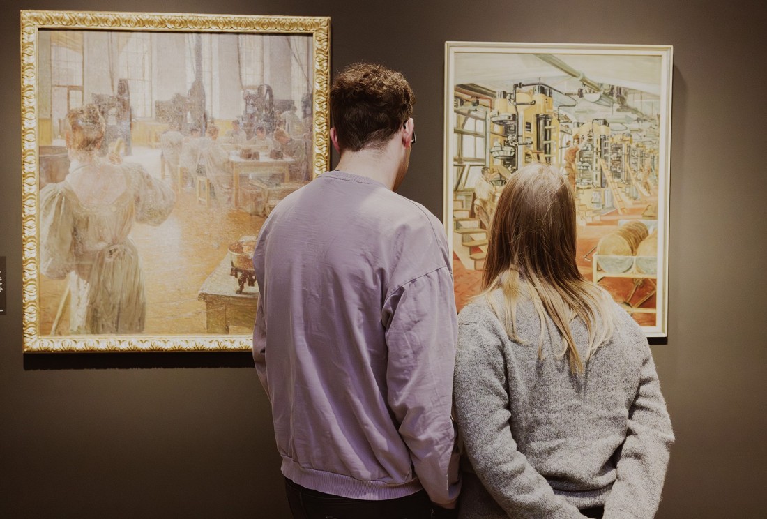 Ein Paar steht vor einem Bild in der Ausstellung "Sch&ouml;ne neue Arbeitswelt. Traum und Trauma der Moderne"