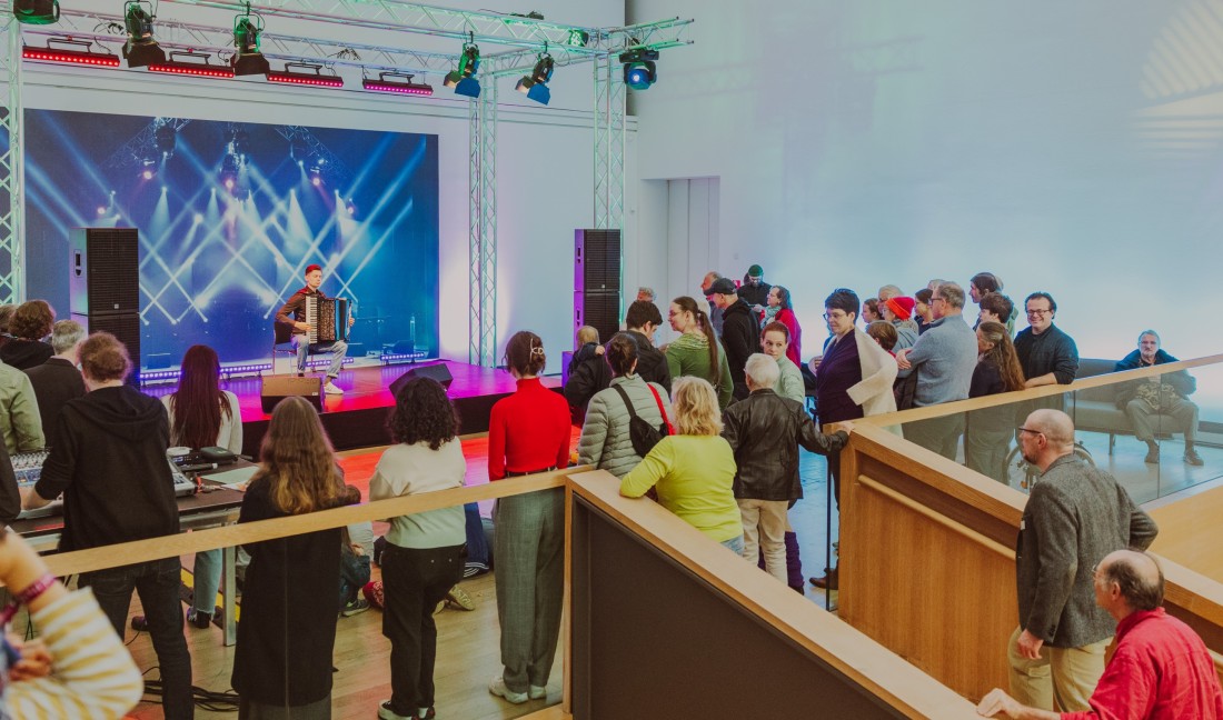 Blick auf die B&uuml;hne der "Open Stage" mit Menschen davor.