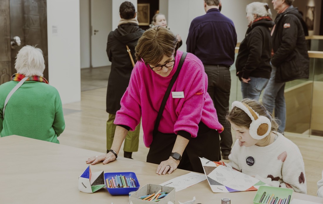 Ein Kind bastelt unter Anleitung.