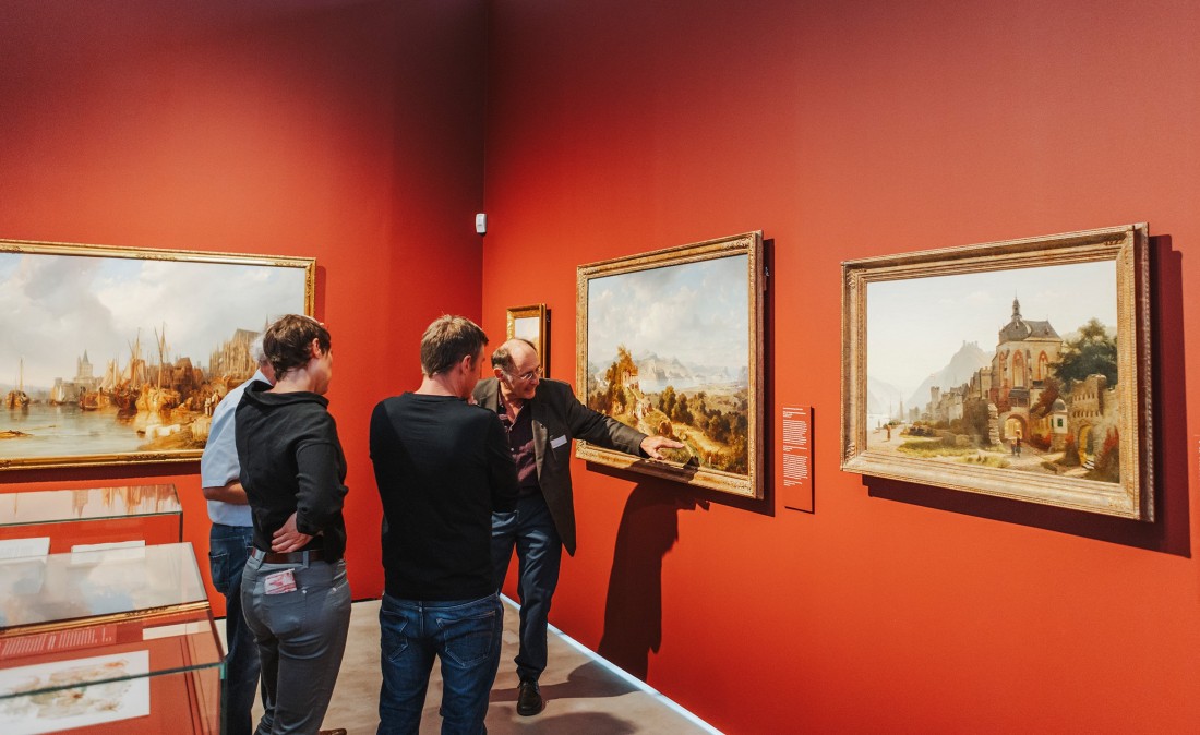 Besucherinnen und Besucher betrachten Gem&auml;lde im Bereich Rheinromantik in der Dauerausstellung WELT IM WANDEL.