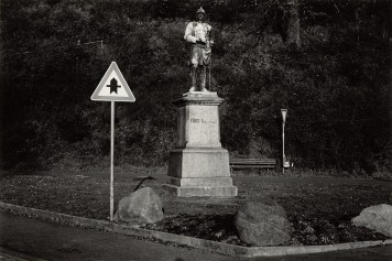 Eine Bismarckstatue an einer Straßengabelung. Daneben ein deutsches Vorfahrtsschild.