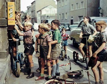 Jungen an einem Bonbonautomaten in einer Straße in Bonn.
